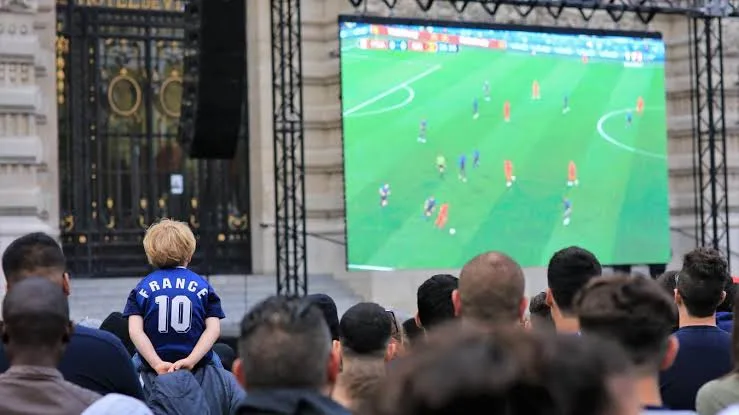 Public rassemblé devant un écran géant loué pour la retransmission d'un match