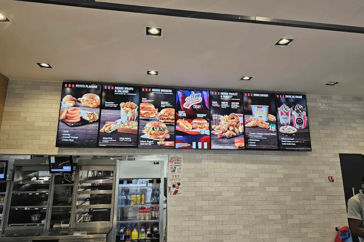 Menu boards LED alignés au-dessus du comptoir d'un restaurant rapide