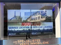 Grand écran LED en vitrine d'une agence immobilière